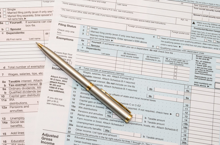 Business pen over tax forms