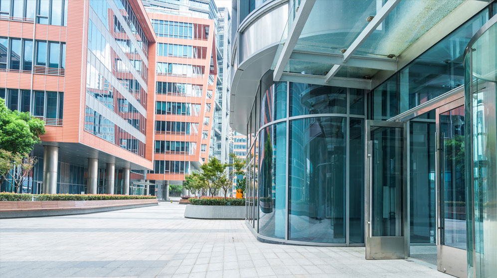 Tiled plaza surrounded by glass, gleaming office towers.