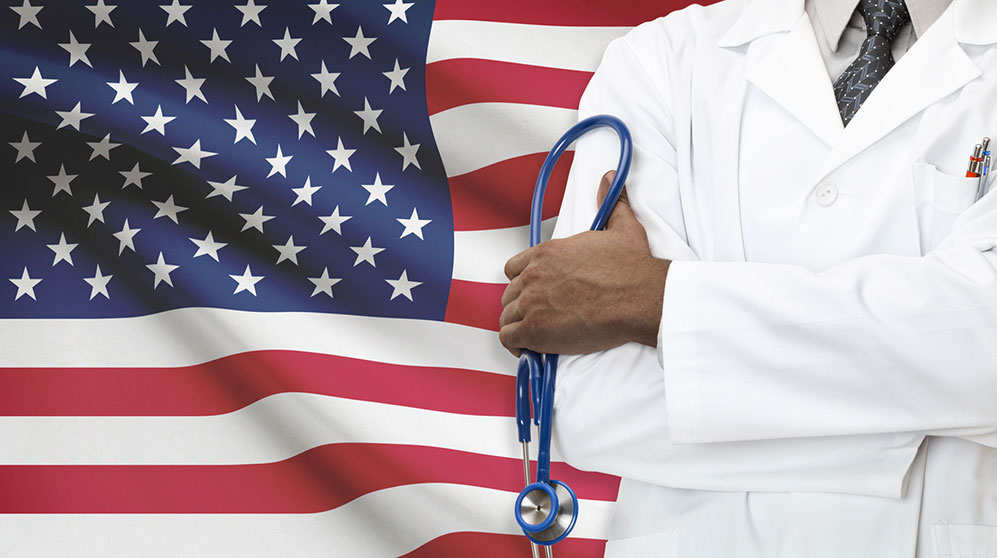 Physician standing in front of an American flag