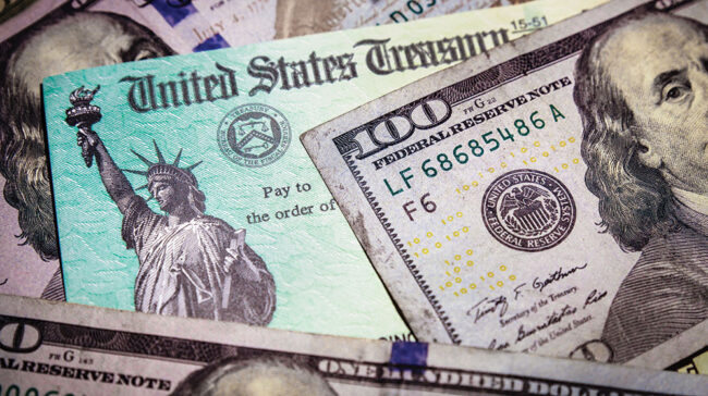 Layers of US bills and US Treasury checks.