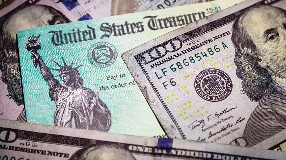 Layers of US bills and US Treasury checks.