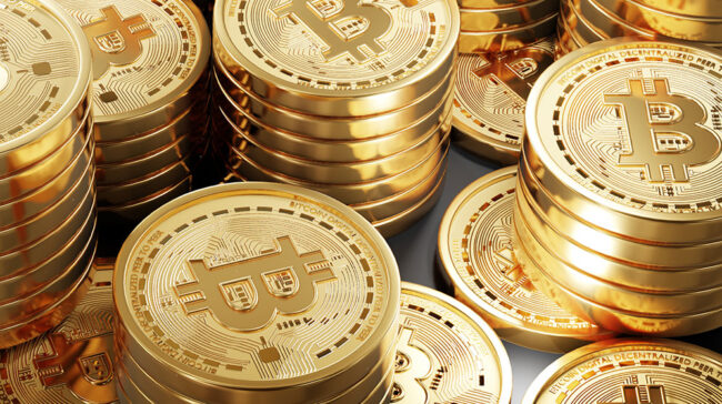 Piles of gold coins with bitcoin symbol.
