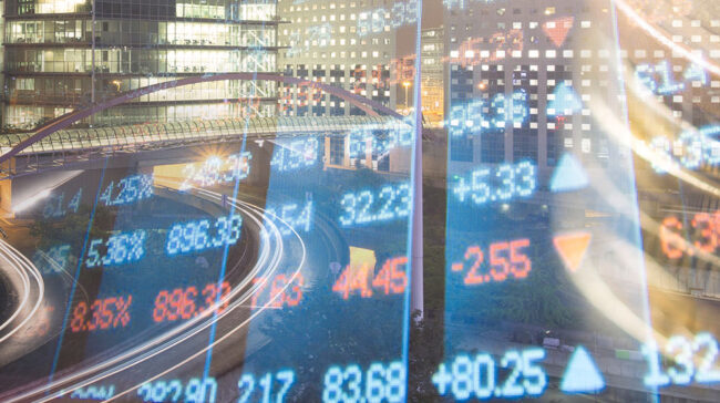 Financial markets digital numbers overlaid a nighttime cityscape.