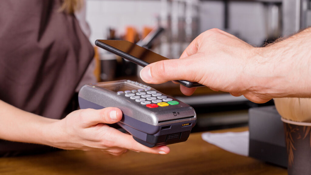 Contact-less transaction being completed between a hand-held point-of-sale device and a mobile phone.