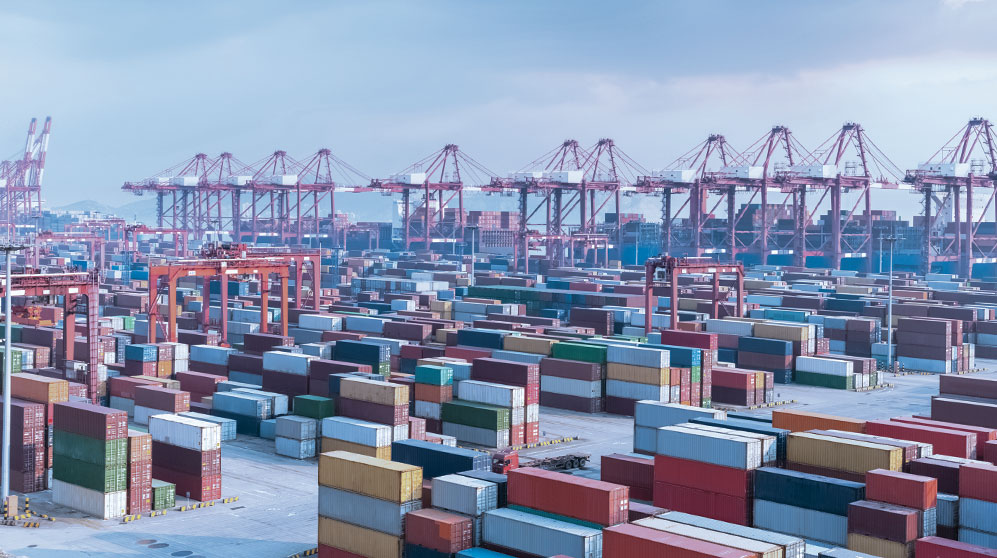 Shipping containers stacked in a busy port.