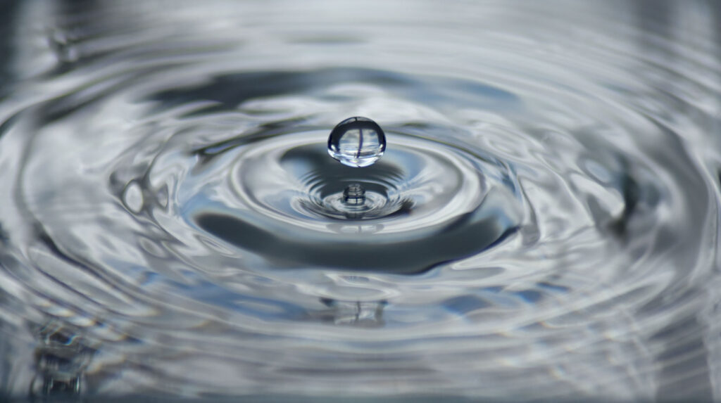 Close up of a water drop and ripple of water.