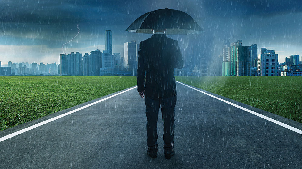 Suited man holding umbrella in rain looking at stylized cityscape.