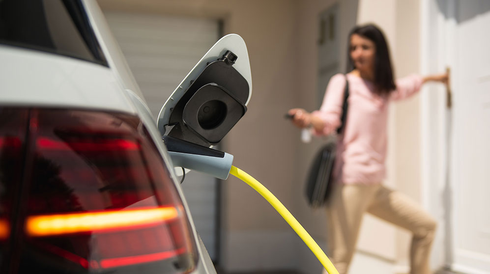 View of an electric vehicle charging cord plugged into car