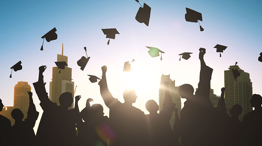 graduates throwing their caps in the air in clebration