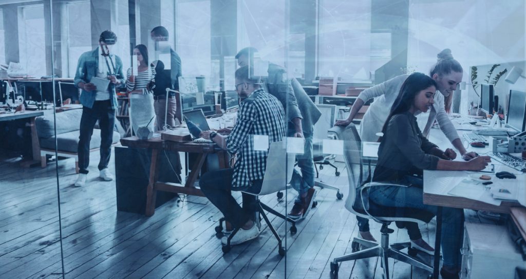 Young office workers collaborating in open plan glass office.