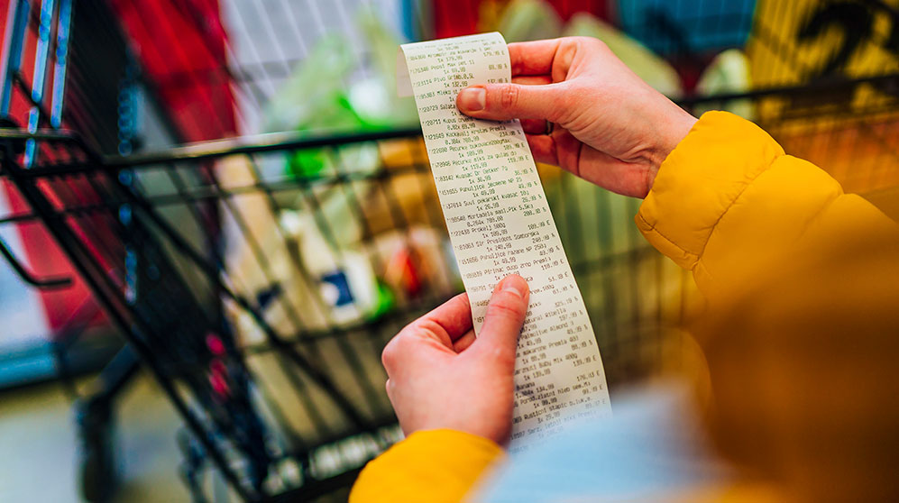 Image showing a person shopping for groceries and looking at receipt