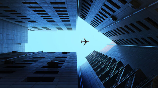 Photo of an arrow made out of buildings, with an airplane flying in the middle