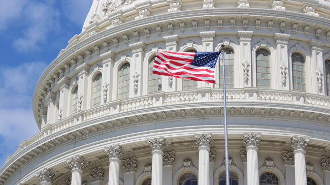Photo of the U.S. flag flying in front of the capital building