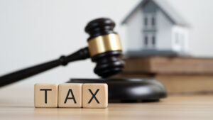 Photo of a house and the word "tax"
