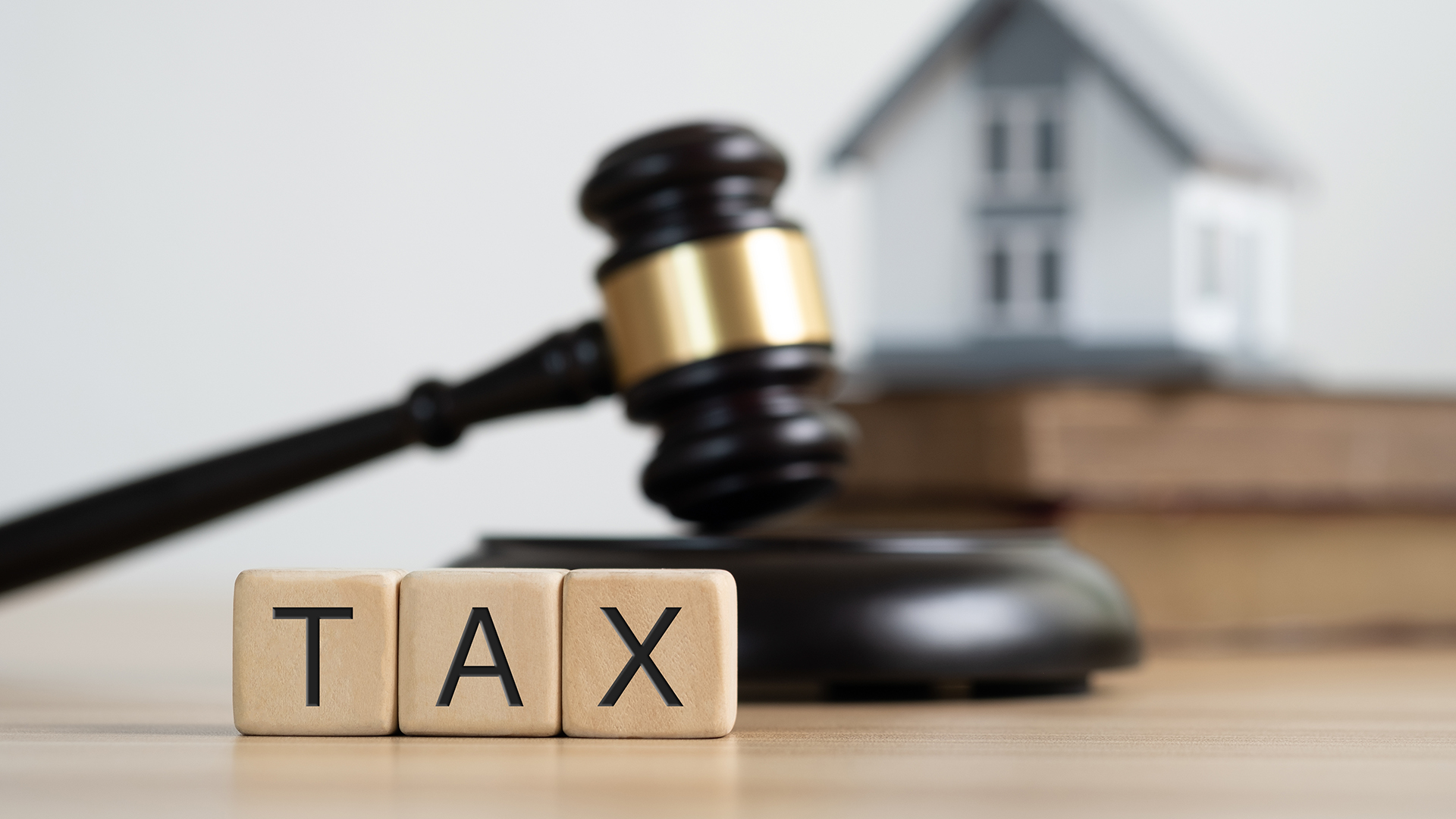 Photo of a house and the word "tax"